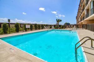 a large blue swimming pool in a apartment building at Oceanfront * Pool * Elevator * Boardwalk in Carolina Beach