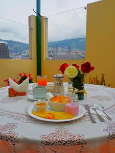 een tafel met een bord eten en bloemen erop bij La Rosario in Quito