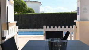 トレ・パチェコにあるVilla with private pool & jacuzzi - CA27LTのテーブルとワインボトルが置かれた柵のあるパティオ