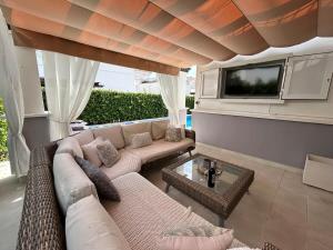 ein Wohnzimmer mit einem Sofa und einem TV in der Unterkunft Villa with private pool and jacuzzi - EN10LT in Torre-Pacheco