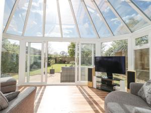 a conservatory with a glass roof with a flat screen tv at Metcalfe House in Somerton