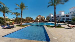 una piscina con palmeras y apartamentos en condominio en Beautiful apartment overlooking the pool- MO2411LT, en Los Tomases