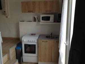 a small kitchen with a stove and a microwave at la loggia in Porto-Vecchio