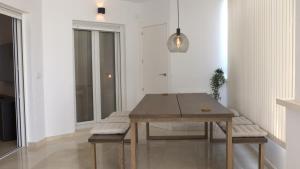 a dining room with a wooden table and benches at Stunning groundfloor apartment - MO2802LT in Los Tomases