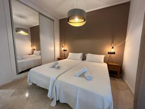 a bedroom with a large white bed with towels on it at Stunning groundfloor apartment - MO2802LT in Los Tomases +53 photos