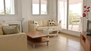 a living room with a couch and a table at Apartment with pool & golf views - ER2113LT in Roldán