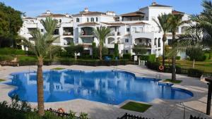 a large white house with a large swimming pool at Apartment with pool & golf views - ER2113LT in Roldán
