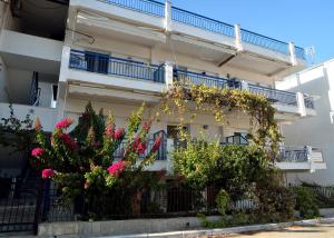 a white building with flowers on the side of it at Maria Konstantinidis Apartments in Nea Potidaea