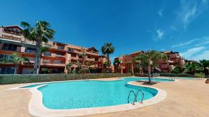 a swimming pool in front of a building with palm trees at Spacious ground floor apartment - EO2402MM in Torre-Pacheco