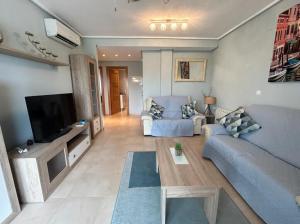 ein Wohnzimmer mit Sofa und Fernseher in der Unterkunft A Lovely Two Bedroom Apartment at La Torre Golf Resort - PA721LT in Roldán