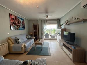 sala de estar con sofá y TV en A Lovely Two Bedroom Apartment at La Torre Golf Resort - PA721LT, en Roldán