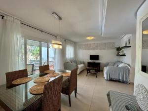 - un salon avec une table, des chaises et un canapé dans l'établissement Apartment with pool & golf views - AA2711LT, à Roldán