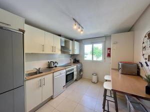 une cuisine avec des placards blancs et un comptoir dans l'établissement Apartment with pool & golf views - AA2711LT, à Roldán