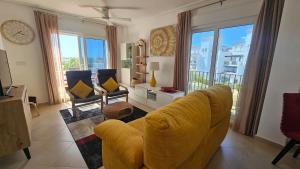 un soggiorno con divano giallo e sedie di Homely apartment on la Torre Golf Resort ER2321LT a Torre-Pacheco