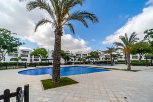 un palmier au milieu d'une piscine dans l'établissement Apartment with pool & golf views - AA2711LT, à Roldán