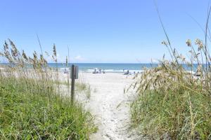 a sandy beach with people on the beach at Oceanfront and Modern Top Location on Ocean Blvd w Pool in Myrtle Beach