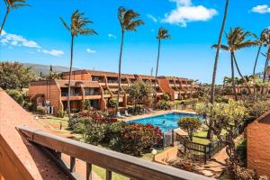 a resort with a swimming pool and palm trees at Kuleana Resort 104 in Kahana