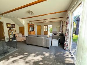 een woonkamer met 2 banken en een raam bij 15 Caverhill Close in Hanmer Springs