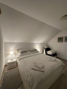 a bedroom with a bed with two towels on it at Apartment Rosandić in Smoljanac