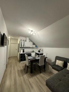 a living room with a dining room table and a kitchen at Apartment Rosandić in Smoljanac