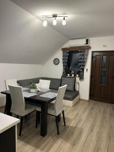 a living room with a table and chairs and a couch at Apartment Rosandić in Smoljanac