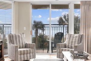 a living room with two chairs and a large window at Oceanfront Luxury Top Location w Lazy River Pool Grills in Myrtle Beach