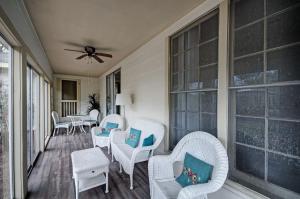 a porch with white chairs and tables and windows at 4 Bedroom 2 Bath Retreat in Jackson with Great Backyard in Jackson
