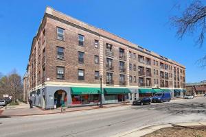 un gran edificio de ladrillo en una calle con coches aparcados fuera en Comfortable Studio Hideaway in Evanston - Elmgate Manor 317, en Evanston