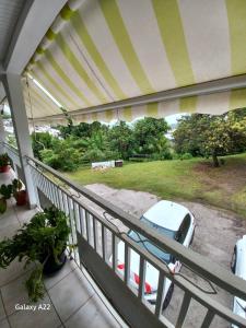 - un balcon avec une voiture garée dans une cour dans l'établissement Le petit coin tranquille, à La Trinité
