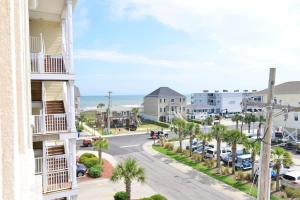 マートルビーチにあるTropical Cherry Grove Ocean View Beach House w Poolのヤシの木やコンドミニアムが並ぶ通りの空中風景