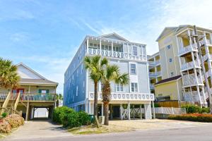 a tall building with palm trees in front of it at Tropical Cherry Grove Ocean View Beach House w Pool in Myrtle Beach