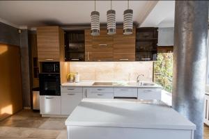 a kitchen with white cabinets and a white counter top at Apartament GOLD in Timişoara