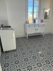 baño con lavabo y encimera con suelo de baldosa en The Gallipoli Flat, en Narrabri