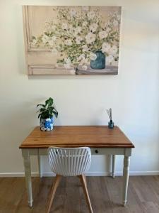 una mesa de madera con una silla y una foto de flores en The Gallipoli Flat, en Narrabri