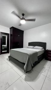 een slaapkamer met een bed en een plafondventilator bij DaVinciHouse in San Pedro Sula