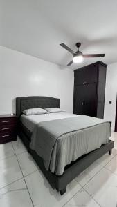 a bedroom with a bed and a ceiling fan at DaVinciHouse in San Pedro Sula