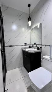 een witte badkamer met een wastafel en een toilet bij DaVinciHouse in San Pedro Sula