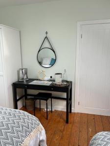 1 dormitorio con escritorio, espejo y cama en An Teach Cnoc, en Monaghan