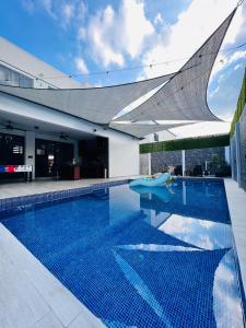 een zwembad met een blauwe tegelvloer en een huis bij DaVinciHouse in San Pedro Sula