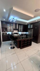 a kitchen with black cabinets and a white tile floor at DaVinciHouse in San Pedro Sula