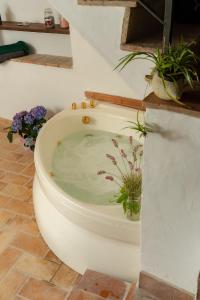 Un inodoro blanco en un baño con flores. en Your luxury room Civitella, en Civitella dʼAgliano