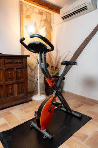 an exercise bike in a room with a table at Your luxury room Civitella in Civitella dʼAgliano