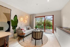 sala de estar con sofá y mesa en Hello Zeeland - Appartement Duinenburg 10- 3 en Domburg