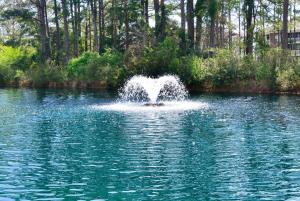 a fountain in the middle of a lake at Massive Waterfront Pool Lakefront Condo Famous Barefoot Resort in North Myrtle Beach
