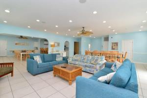 un grand salon avec des canapés bleus et une table dans l'établissement Tropical Rays Huge Cherry Grove House w Pool, à Myrtle Beach