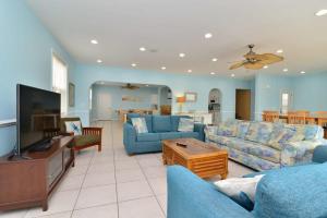 a living room with two blue couches and a television at Tropical Rays Huge Cherry Grove House w Pool in Myrtle Beach