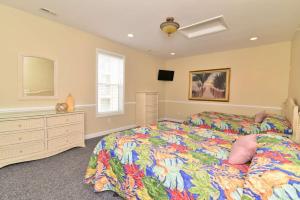 a bedroom with a bed with a colorful comforter at Tropical Rays Huge Cherry Grove House w Pool in Myrtle Beach