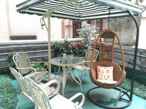 un patio con mesa, sillas y sombrilla en California Hotel, en Hong Kong