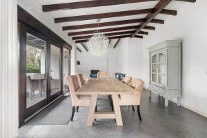 een eetkamer met een houten tafel en stoelen bij Hello Zeeland - Villa Park Reygersbergh 11 in Oostkapelle