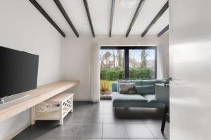 ein Wohnzimmer mit einem Sofa und einem TV in der Unterkunft Hello Zeeland - Villa Park Reygersbergh 11 in Oostkapelle
